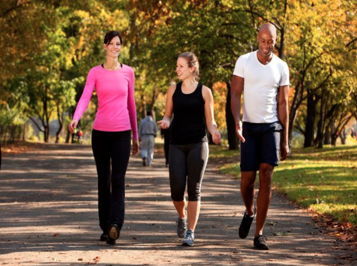 three people exercising in a park