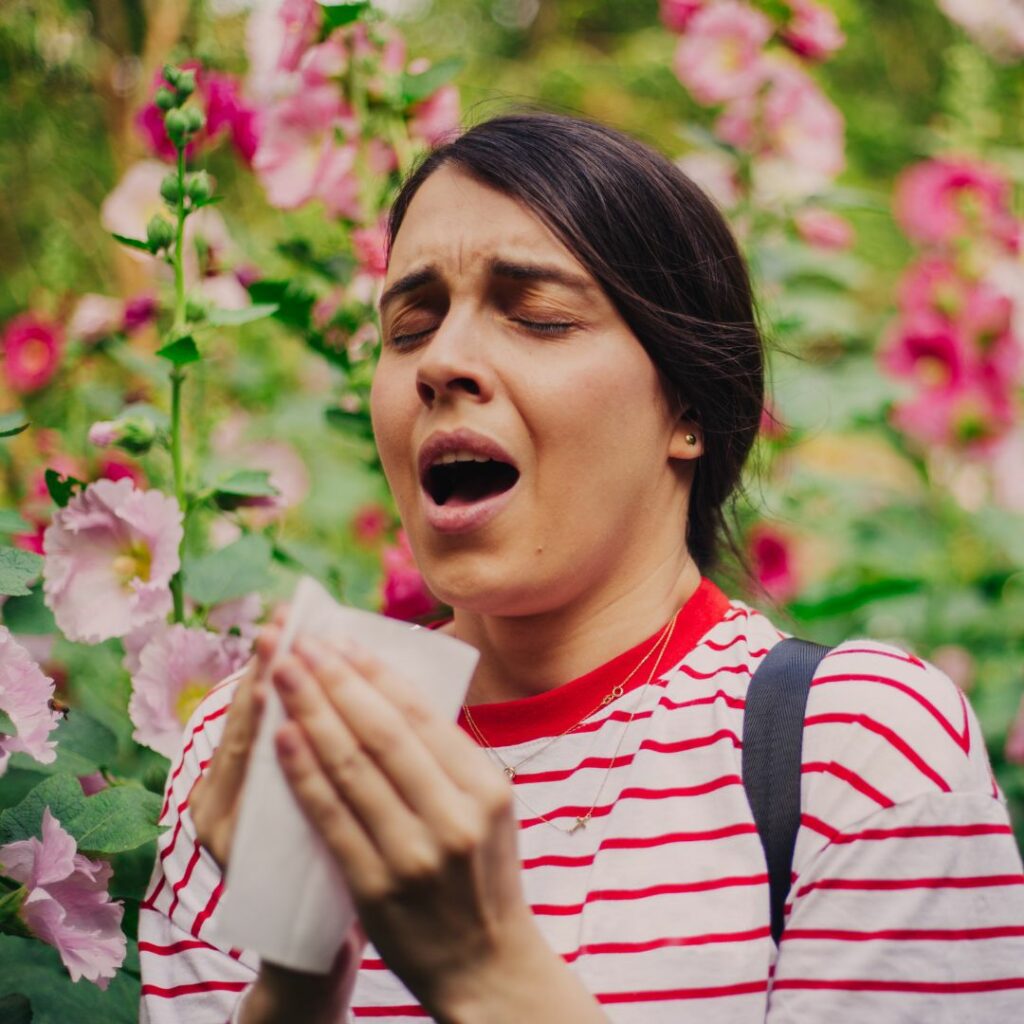 Person in flower field sneezing