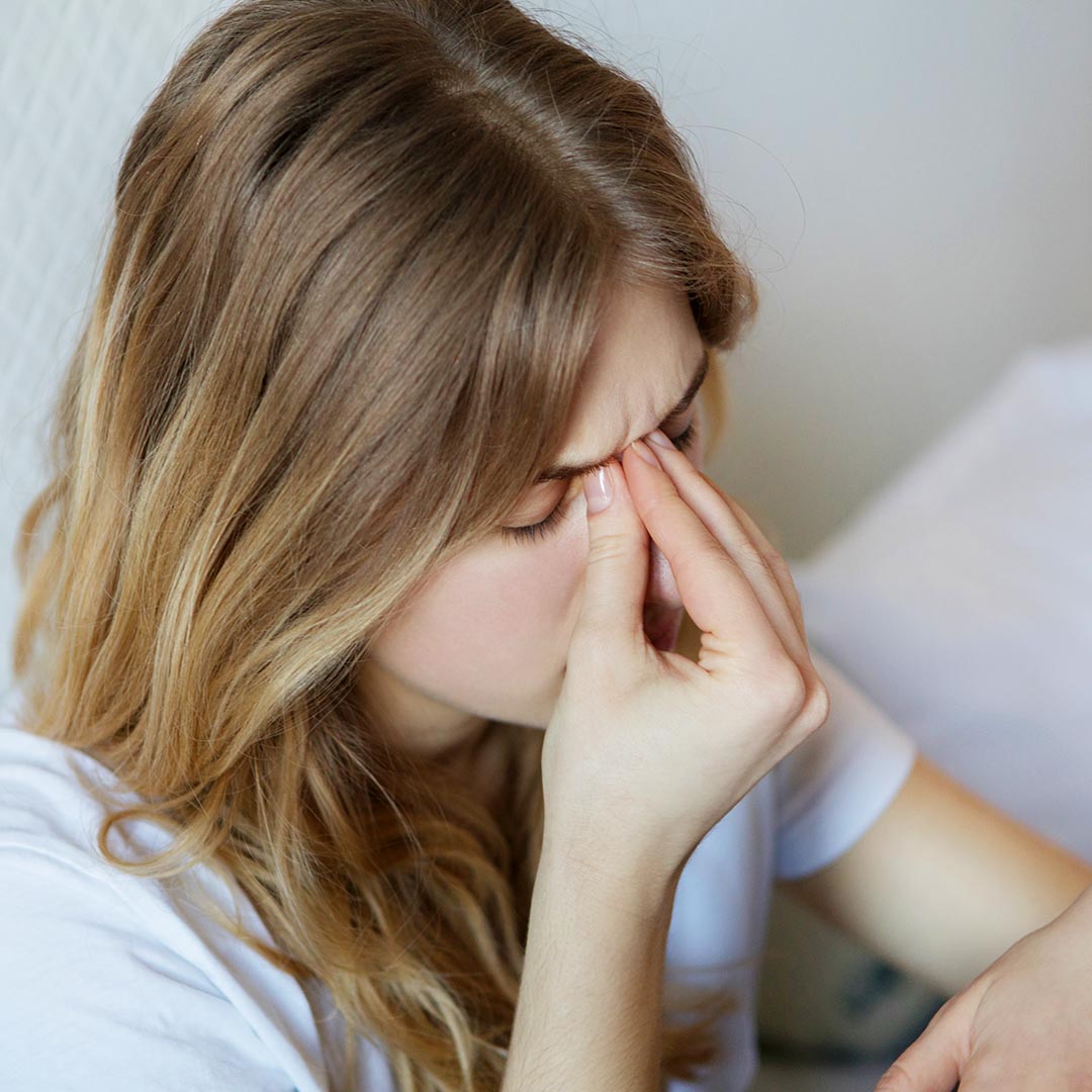 Woman holding the bridge of her nose