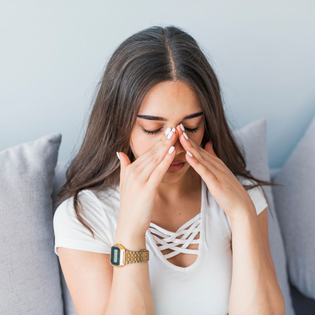 woman holding nose