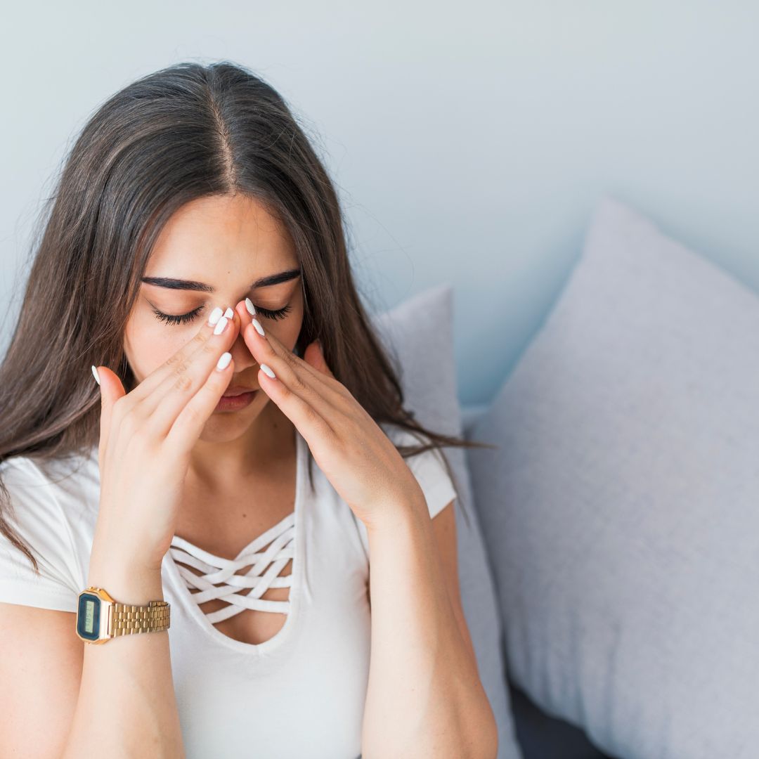 Woman applying pressure to sinuses 